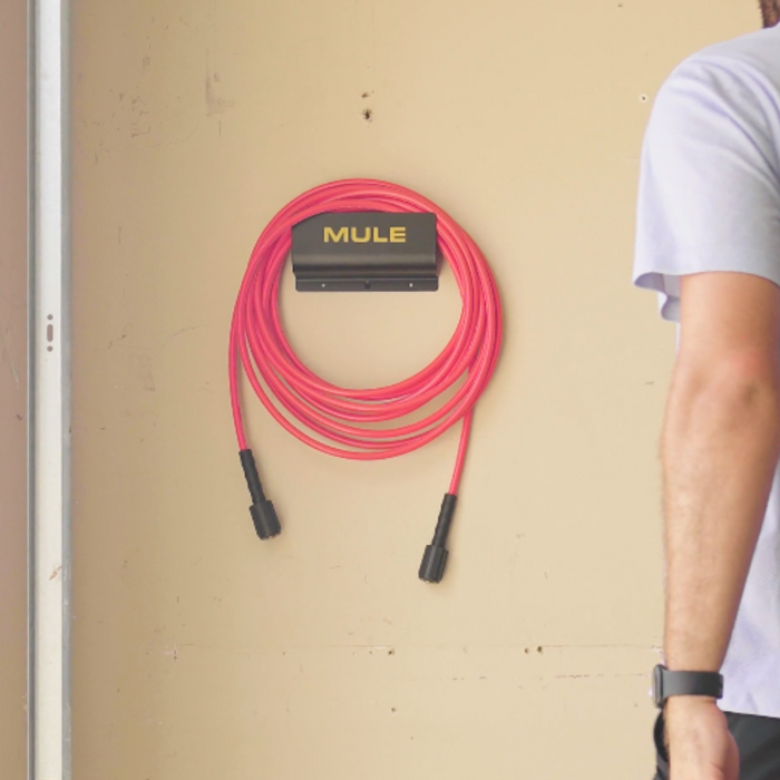 MULE wall bracket with hose hanging on a beige wall
