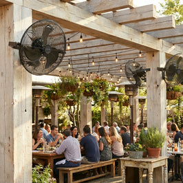 People dining under a wooden pergola with MULE outdoor fans