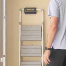 Person standing next to a MULE storage bracket with ladder hanging on bracket