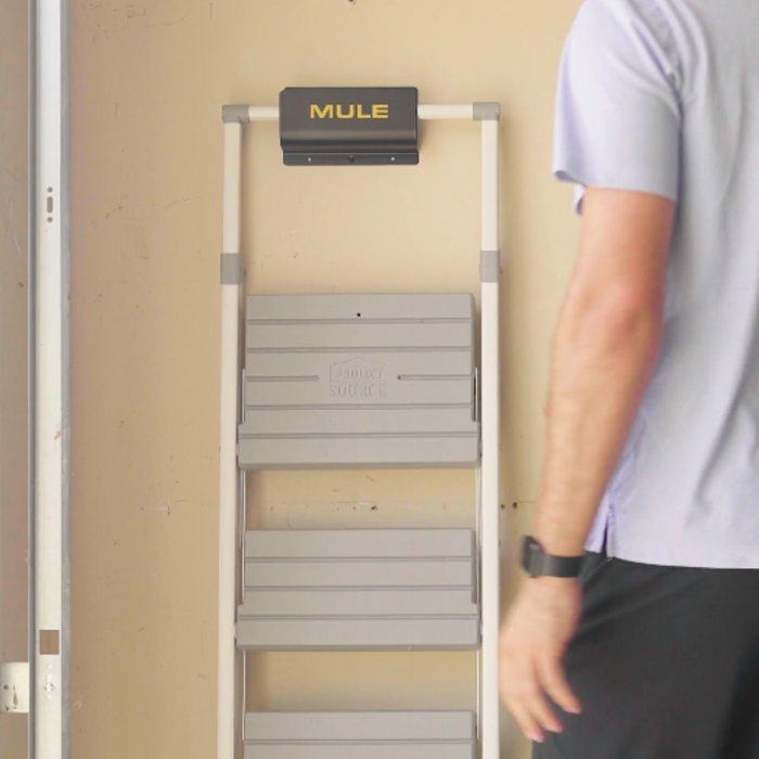 Person standing next to a MULE storage bracket with ladder hanging on bracket